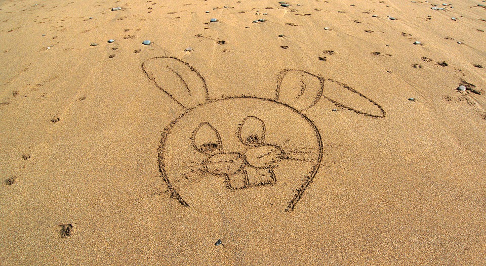 Coelhinho da páscoa desenhado na areia da praia